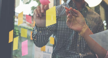 Product managers discussing post its on walls