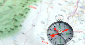 Compass,Photoed,Against,The,Background,Of,The,Map