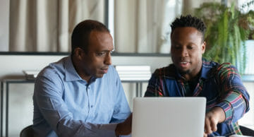 two men looking at a laptop together shutterstock image